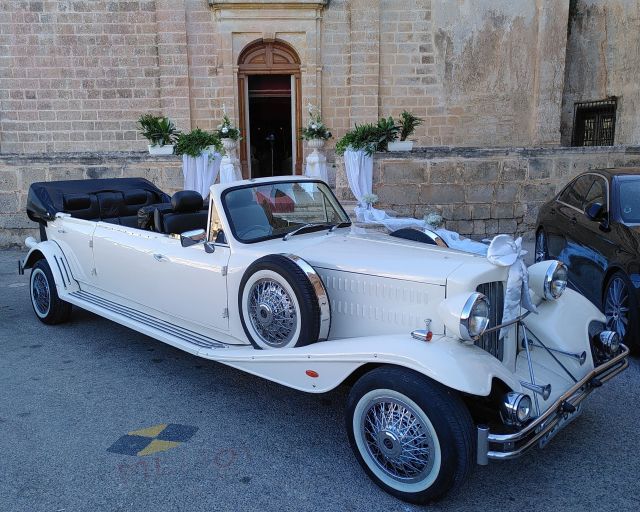 Für Hochzeit geschmückter weißer Oldtimer Caprio vor der Kirche