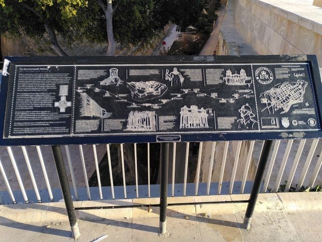 Gedenktafel aus Metall auf drei Stützten am City Gate zu Valletta mit den Stationen Queen Elisabeth in Valletta 2015