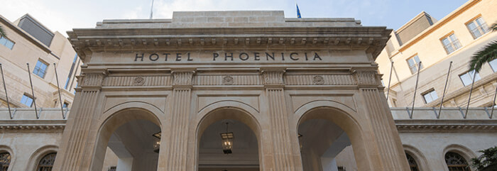 Der mächtige Eingang mit drei Torbogen und darüber der Hotelname Hotel Phoenica